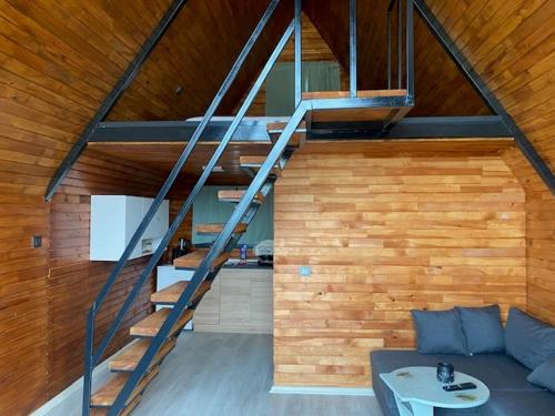 a living room with a staircase and a couch at NefesURLA Bungalov4 in Urla