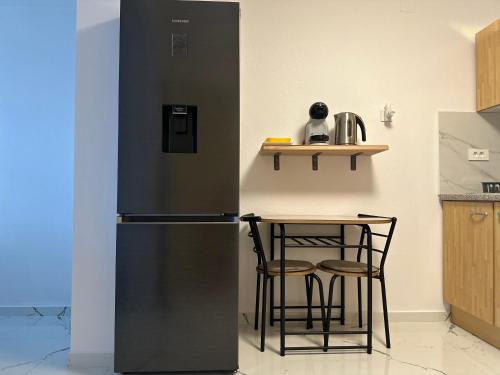 a black refrigerator in a kitchen with a table at Apartment Samanta in Supetar