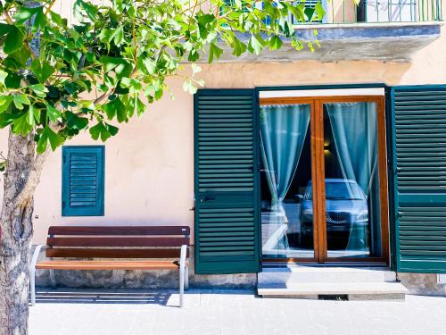 a bench in front of a building with green shutters at Ca' di Leo in Santa Fiora