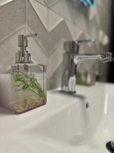 a soap dispenser sitting on a bathroom sink at Apartment Samanta in Supetar