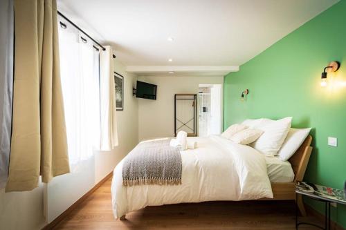 a green bedroom with a bed and a window at L'Albatros 005 - Hypercentre * Cosy * Wifi in Saint-Quentin