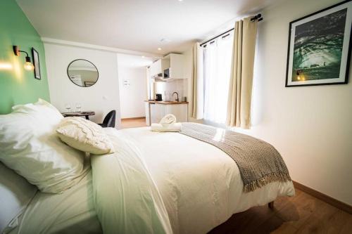 une chambre avec un lit avec des draps blancs et une fenêtre dans l'établissement L'Albatros 005 - Hypercentre * Cosy * Wifi, à Saint-Quentin