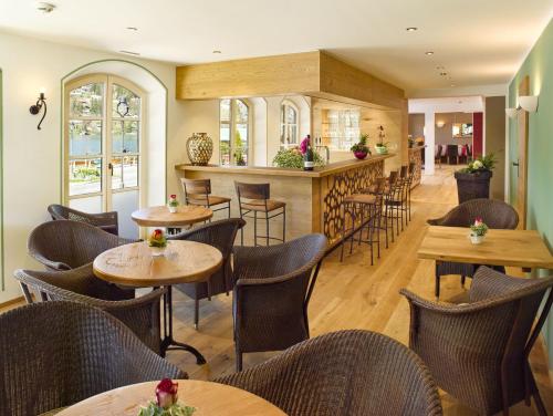 um restaurante com mesas e cadeiras e um bar em Seehotel Waltershof em Rottach-Egern