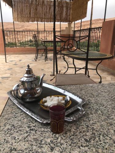 a tray with a tea kettle and a plate of food at ACHAHOUD CHEz LA BELLE FIBULLE in Aït Fars