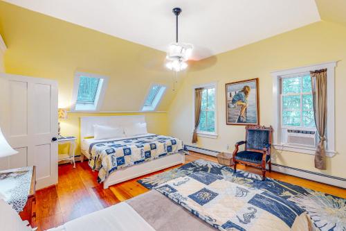 a bedroom with a bed and a chair at Farmhouse on the Cove in Penobscot