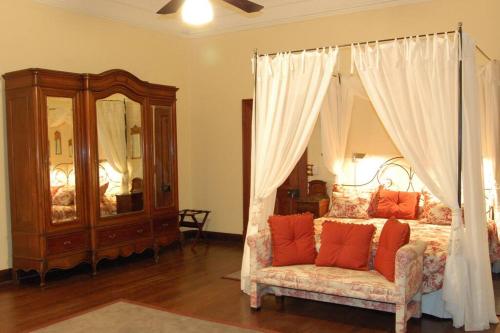 a bedroom with a canopy bed and a chair at Casco histórico de Estancia in Monte Buey