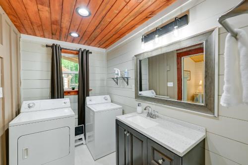 a bathroom with a sink and a toilet and a mirror at Near Main Street with Hot Tub Retreat in Hiawassee! in Hiawassee