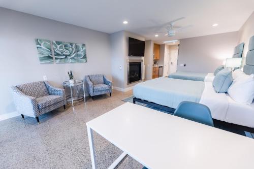 a living room with a bed and a couch and chairs at Baywood Inn Bed & Breakfast in Los Osos