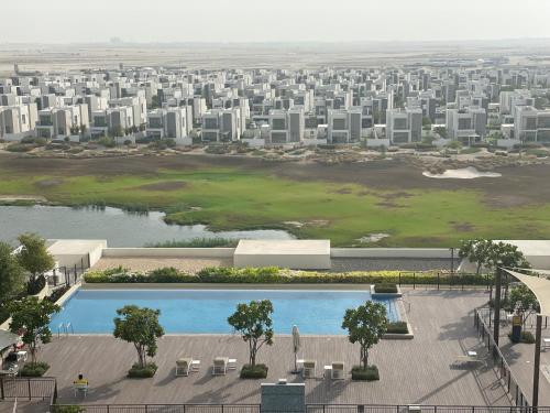 an aerial view of a city with a pool and buildings at Emaar South - Two Bedroom Apartment with Pool and Golf Course View in Dubai