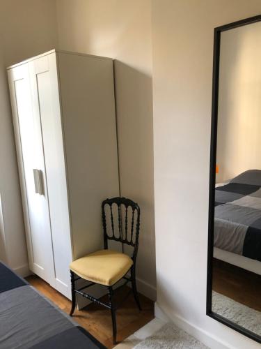 ein Schlafzimmer mit einem Stuhl und einem Spiegel in der Unterkunft Royal in Blois