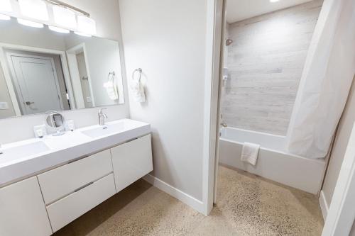 a white bathroom with a sink and a bath tub at Baywood Inn Bed & Breakfast in Los Osos