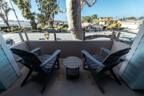 a balcony with two chairs and a table and a tree at Baywood Inn Bed & Breakfast in Los Osos