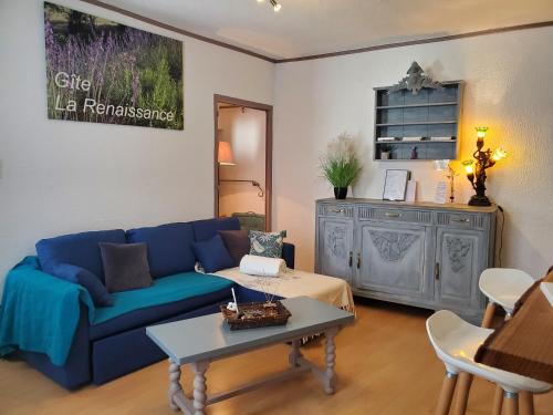 a living room with a blue couch and a table at La Renaissance 50m2 - Indépendant & terrasse in Saint-Ambroix