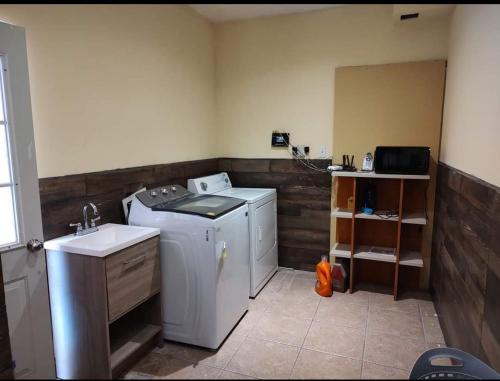uma cozinha com uma máquina de lavar roupa e um lavatório em casa consulado em Ciudad Juárez