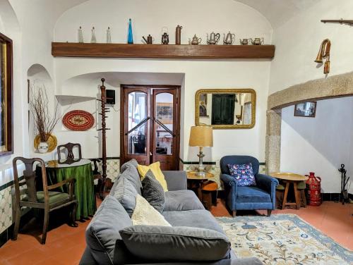a living room with a gray couch and chairs at Hotel Solar de Monfalim in Évora