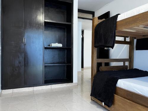1 dormitorio con litera y armario negro en Apartamento Cerca Al centro en Valledupar