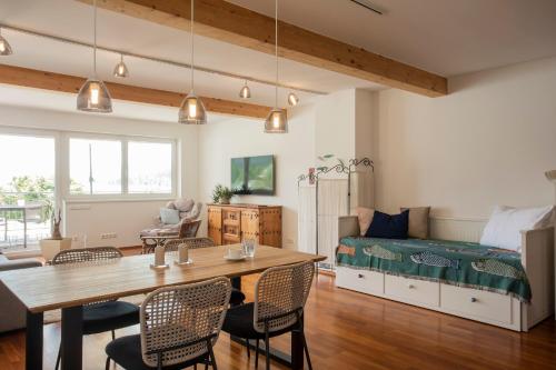 a living room with a table and a bed at Seeapartment da Leopoldo I in Velden am Wörthersee