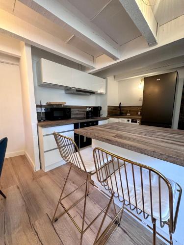 a kitchen with two chairs and a table and a counter at L'Etoile - Duplex cosy de 50m2 en centre-ville in Nîmes