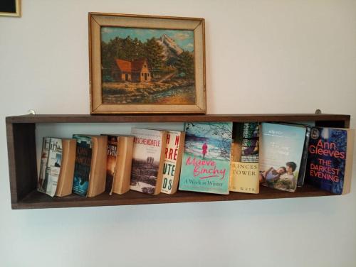 uno scaffale con libri e una foto sopra di Dar Doukkala Oualidia a Oualidia