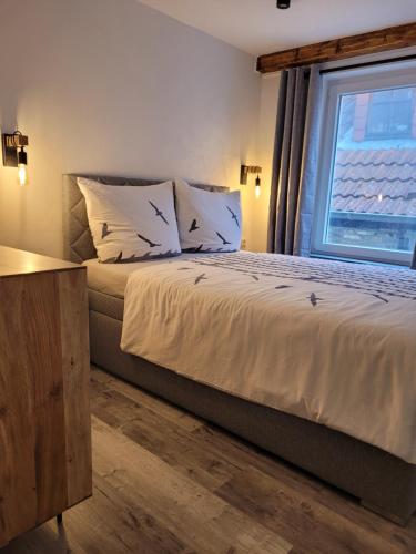 a bedroom with a large bed with a window at FeWo Todeskino "Möwennest" in Heiligenhafen in Heiligenhafen