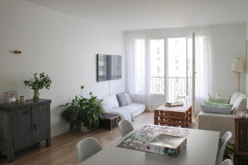 un salon avec un canapé et une table dans l'établissement Through apartment - Place de la Réunion, à Paris