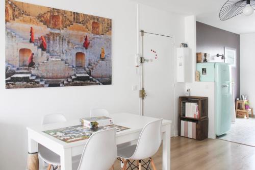 une salle à manger avec une table blanche et des chaises blanches dans l'établissement Through apartment - Place de la Réunion, à Paris