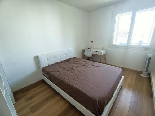 1 dormitorio con cama, escritorio y ventana en Appartement spacieux et bien équipé Hôpitaux Facultés en Montpellier