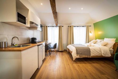 Il comprend une chambre avec un lit et une cuisine avec un évier. dans l'établissement L'Albatros 004 - Hypercentre * Cosy * Wifi, à Saint-Quentin