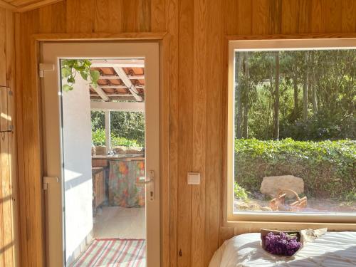 una camera con finestra e un letto in una stanza di Nativo Natureza Pink Wood Cabin a Cela