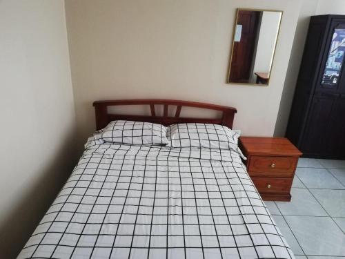 a bedroom with a bed and a dresser and a mirror at Hostal Amazónico Bello Amanecer in Nueva Loja