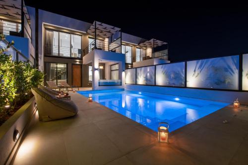 a house with a swimming pool at night at Cretan Queen Residences in Aghii Apostoli