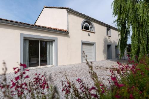 a white house with flowers in front of it at Chez PhiL in La Pomarède