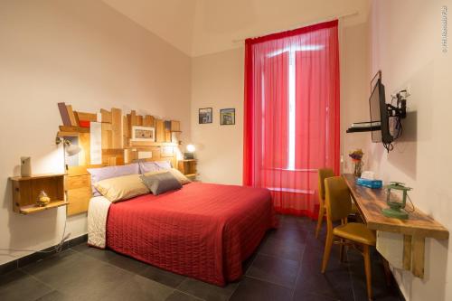 a bedroom with a bed and a desk and a red window at The Bellini House by House In Naples in Naples
