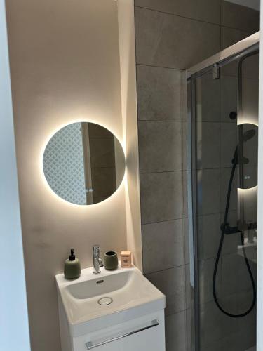 uma casa de banho com um lavatório branco e um espelho. em Le Madeleine - Cosy & Rénové - Face Tram em Orléans