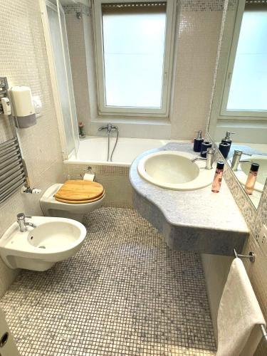 a bathroom with a toilet and a sink and a tub at Ammiragli Vatican Experience in Rome
