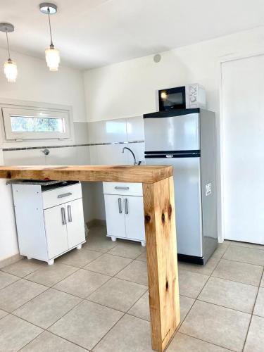 a kitchen with a wooden counter and a refrigerator at Aire de las Sierras in Embalse