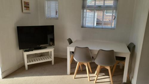 a small living room with a table and a television at Peaceful Bournemouth Family Retreat in Bournemouth