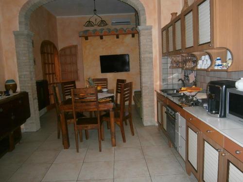 a kitchen with a table and chairs and a television at Bed and Breakfast Su Niu in Quartucciu