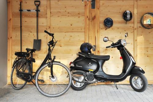 a scooter and a bike parked next to a wall at Mazury Haus in Ruciane-Nida