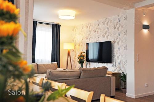 a living room with a couch and a tv at Mazury Haus in Ruciane-Nida