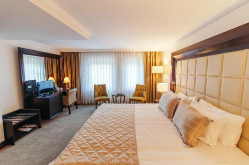 a hotel room with a large bed and a desk at CK Farabi Hotel in Ankara