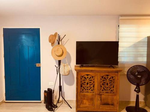 a living room with a television and a blue door at Mini Casa Campestre Privada in La Playa