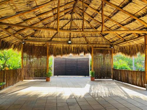 a large wooden pavilion with a black door at Mini Casa Campestre Privada in La Playa
