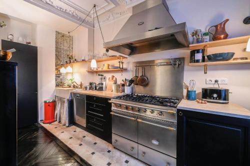 a large kitchen with stainless steel appliances and counters at Bright apartment - near Place Pigalle in Paris