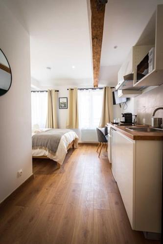une cuisine et une chambre avec un lit dans une pièce dans l'établissement L'Albatros 003- Hypercentre * Cosy * Wifi, à Saint-Quentin