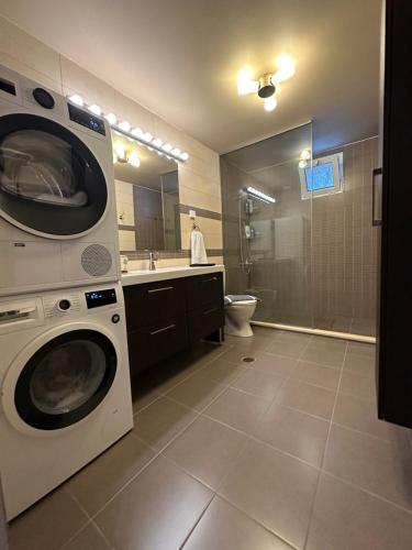 a bathroom with a washer and dryer in it at Spenny Sunrise Apartment in Xiropigado
