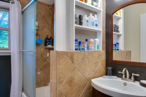 uma casa de banho com um chuveiro, um lavatório e um espelho. em Cozy Nashville Getaway Near Lake Radnor and Downtown em Nashville