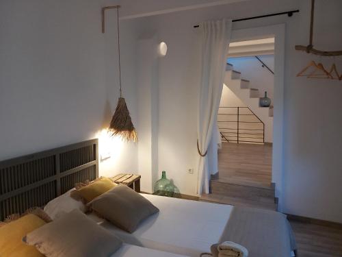 1 dormitorio con 1 cama con sábanas y almohadas blancas en Townhouse Sa Casa, en Sineu
