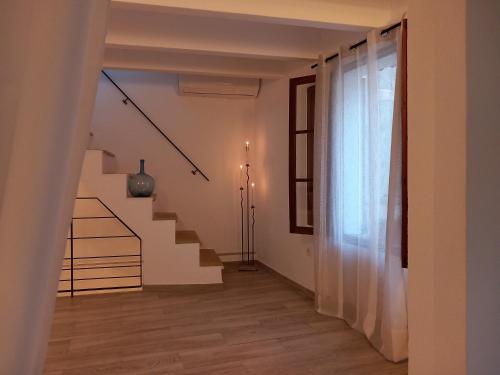 a white hallway with stairs and a window at Townhouse Sa Casa in Sineu