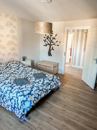 a bedroom with a bed and a tree on the wall at La casa de Mimi in Sarralbe